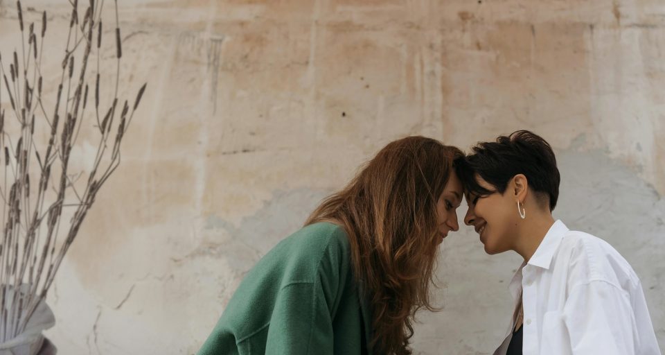 Two women touching foreheads and smiling.
